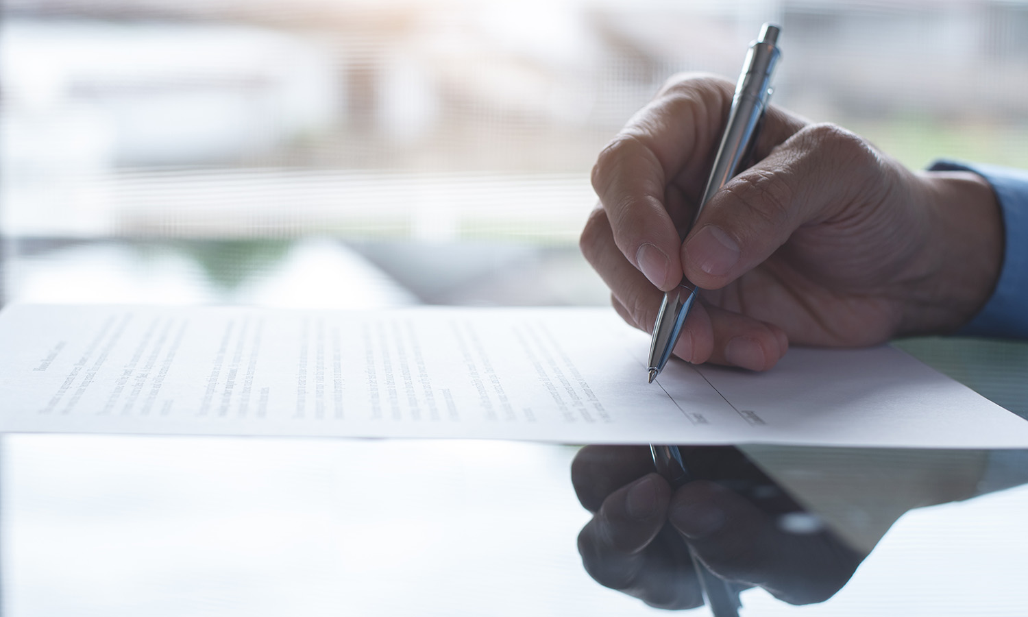 Signing a loan document with a pen